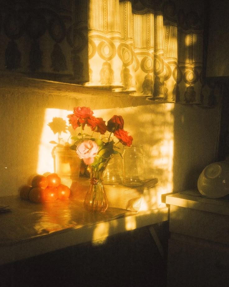 A vase of fresh flowers sits on a kitchen counter in a vintage-style kitchen, photographed with a warm sepia-toned filter.